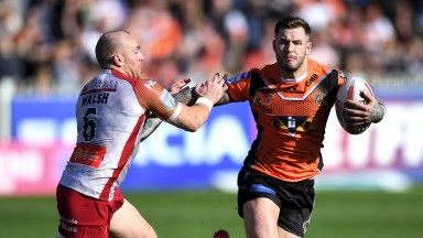 Zak Hardaker fends off Catalans half-back Luke Walsh