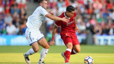 Tranmere’s Liam Ridehalgh (left) gets to grips with Roberto Firmino of Liverpool
