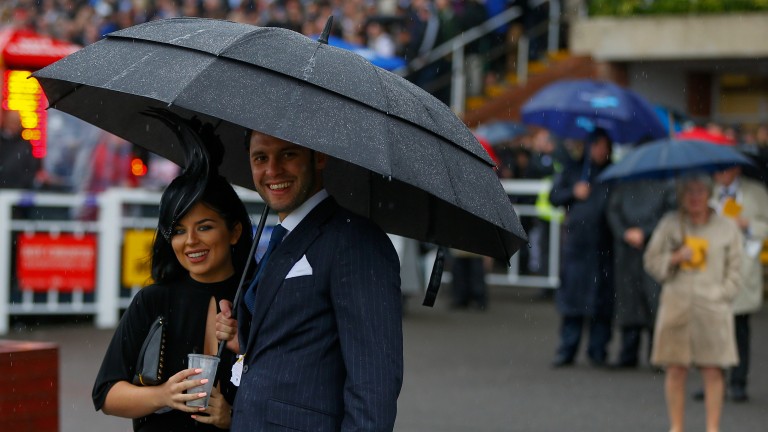 Goodwood: two well-dressed racegoers brave the rain