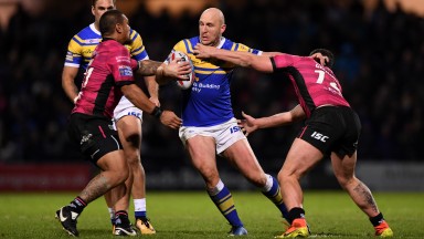 Carl Ablett of Leeds is tackled by Sika Manu and Mark Minichiello of Hull