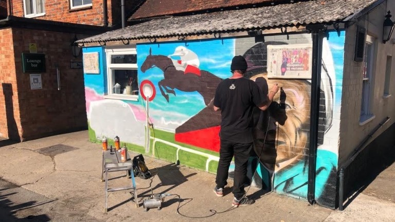 Ed Russell applies some of the finishing touches to the mural